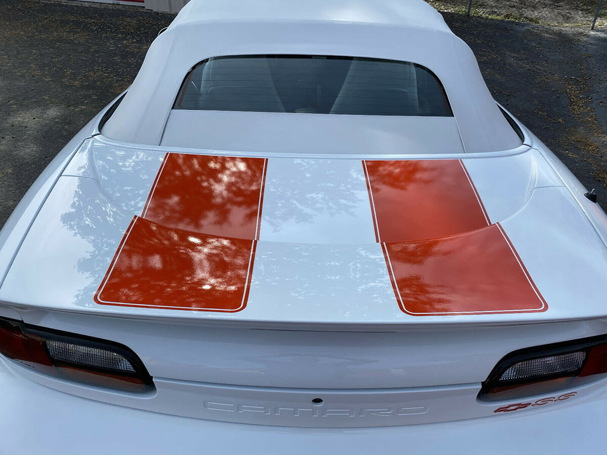 White 1997 Chevy Camaro SS with red stripes top up