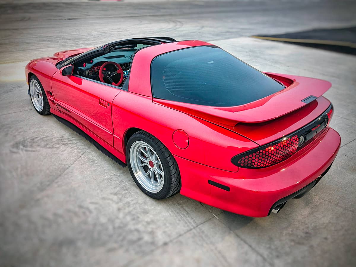 Red Pontiac Trans Am WS6 with targa top and custom Villante steering wheel with NRG carbon fiber quick release hub